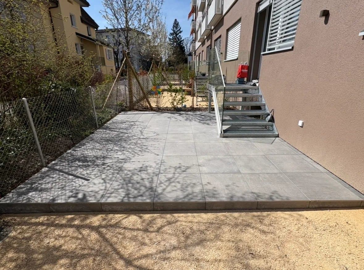 Terrasse extérieure en dalles de grès cérame gris posées sur plots à Nyon
